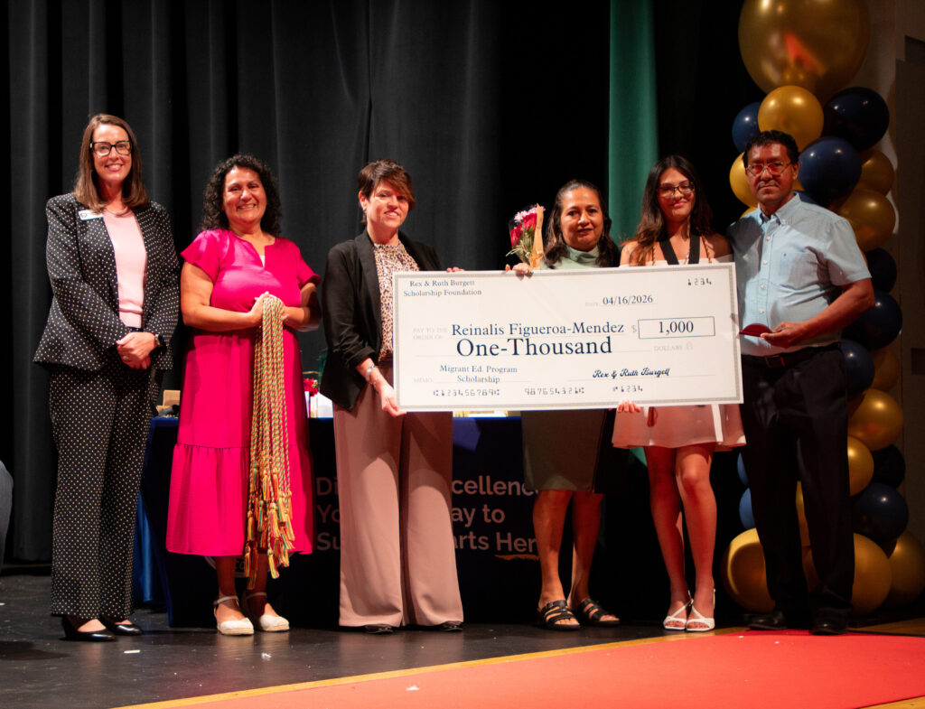 School district leaders awarding a scholarship to a migrant student and family.